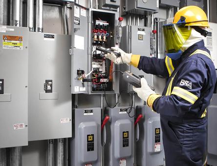 Técnico con equipo de protección frente a tableros eléctricos