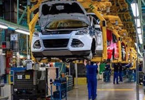 Carrocería elevada sobre una línea de ensamble con operarios debajo