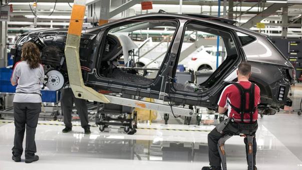 Carrocería en línea con operarios, uno de ellos con exoesqueleto