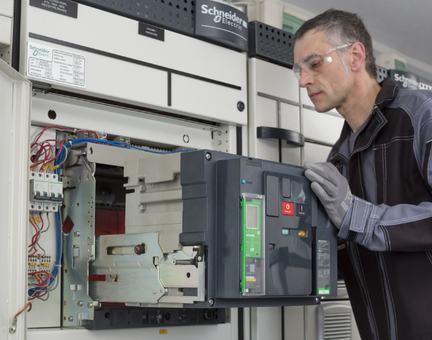 Técnico trabajando en un tablero eléctrico con interruptor de baja tensión